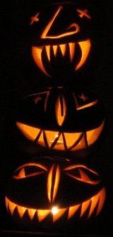 Three jack-o'-lanterns illuminated from within by candles.